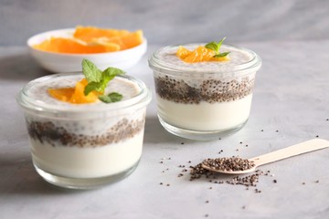 Healthy bowls of yogurt or curd and Chia seeds, topped with chopped oranges and mint leaves. Chia seeds pudding dessert.