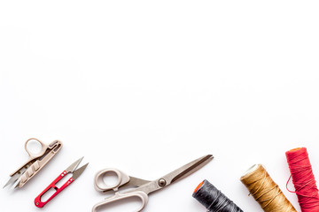 Tailor's work desk. Thread and sciccors on white background top-down copy space