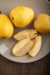 Naklejka na ściany i meble Ripe yellow pears on a wooden table