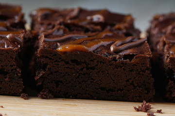 Close up of moist dark chocolate brownies over wooden table.