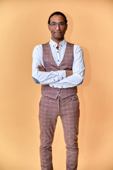 Vertical Portrait Young man with short-haired African American in a business suit on a pink background. Standing and talking right in front of the camera.