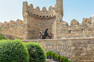 Ancient cast-iron cannon on wooden wheels, on the fortress wall