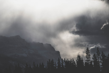 Stormy black and white photograph of the mountains with heavy fog and clouds