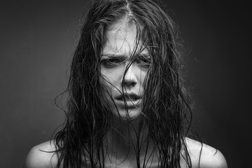 Expressive black white portrait of a young attractive girl with wet dark hair