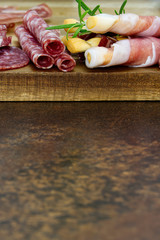Meat and cheese plate antipasti snack with Prosciutto ham, Parmesan, Blue cheese, Cantaloupe melon and Olives on olive wood serving board with copy space