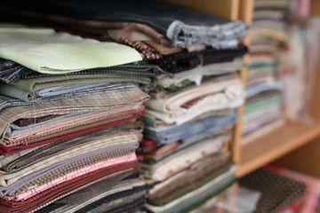 stack of pieces fabric many pattern on shelf, material recycle for clothing fashion design