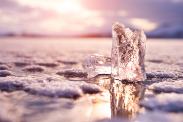 Ice on the frozen lake at sunset. Macro image, shallow depth of field. Winter nature background