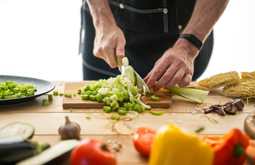 Chopped celery and vegetables on a wooden table. View from above