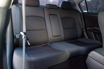 Close-up on rear seats with velours fabric upholstery in the interior of an old Japan car in gray after dry cleaning. Auto service industry.