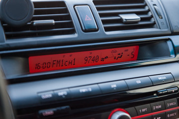 Display of the multimedia system of the car is glowing in red at night indicating the radio...