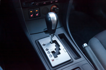Automatic gear knob in the passenger compartment in black for driving and acceleration. Abstract image of fast speed.