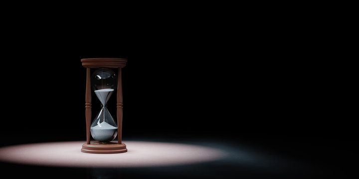 Classic Wooden Hourglass Spotlighted on Black Background
