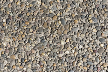 Pebble stone wall texture. Finishing the foundation of the house with stone pebbles