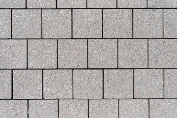 The texture of the square paving slabs of gray in a European city
