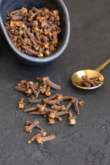 Natural clove spice on dark concrete background