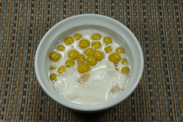 Pumpkin Chinese glutinous sticky rice ball with the coconut milk in the glass bowl. Chinese traditional dessert menu in special ceremony or Chinese New year party. 