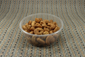 Deep fried cashew nut with salt. Baked snack for party. Mock up of nut product in plastic packaging. 