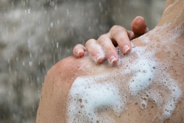 Young adult girl taking shower, standing in bathroom