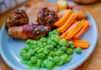  Top down view of traditional roast lunch on a blue oval dinner plate