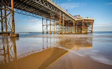 Naklejka premium Long exposure photo of a Victorian pier on a sandy beach