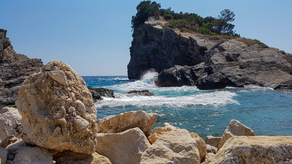 Panoramic view of pebble beach with clear azure blue water and layered rocks, beautiful sea landscape with picturesque sea and horizon line, Montenegro
