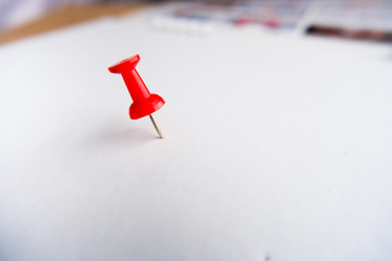 Top view of push pins on white paper background