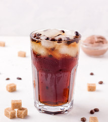 iced coffee on a white background. next to cane sugar.
