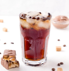 iced coffee on a white background. next to a chocolate bar. coffee shop soda