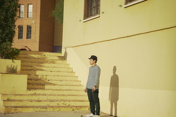 Asean young man against yellow buildings bakcground in the city of Villajoyosa, province of Alicante, Autonomous community of Valencia, Spain