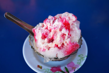 Close up Thai style shaved ice dessert topped with condensed milk, syrup and sweet toppings