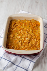 Homemade Funeral Potatoes Casserole in a dish, side view.