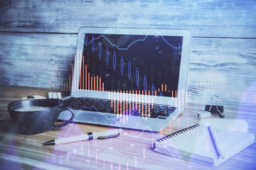 Double exposure of chart and financial info and work space with computer background. Concept of...