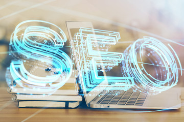 Multi exposure of table with computer and seo drawing hologram. Search optimization concept.