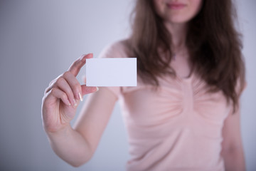 Young woman hand showing blank white bussines card.