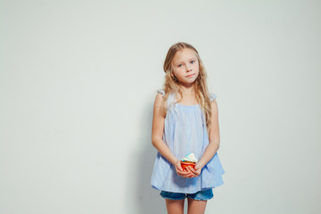 beautiful little girl blonde with cake and candy portrait of food