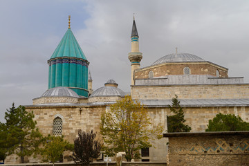 Blue tiled tomb of dervish founder Mevlana or Rumi now a musuem with ancient wall of Dede tomb Konya Turkey