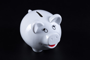 White piggy bank with coin bars on blue background.