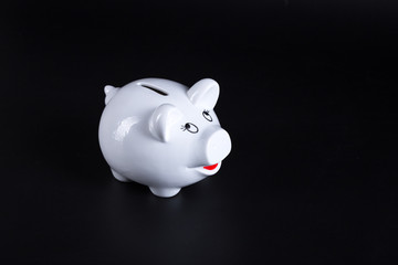 White piggy bank with coin bars on blue background.