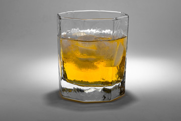 A glass of whiskey with ice on the white background.