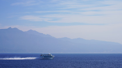 Fototapeta na wymiar unusual passenger speed boat in japan. transportation of passengers on the Japanese islands. hydrofoil boat against the mountainous coast of Japan on a sunny day