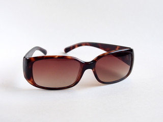 Brown-rimmed sunglasses, women's accessory. Summer season, sea, beach.