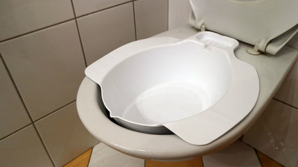 Additional bidet, medical device bowl for sitting baths, on the toilet. - obrazy, fototapety, plakaty