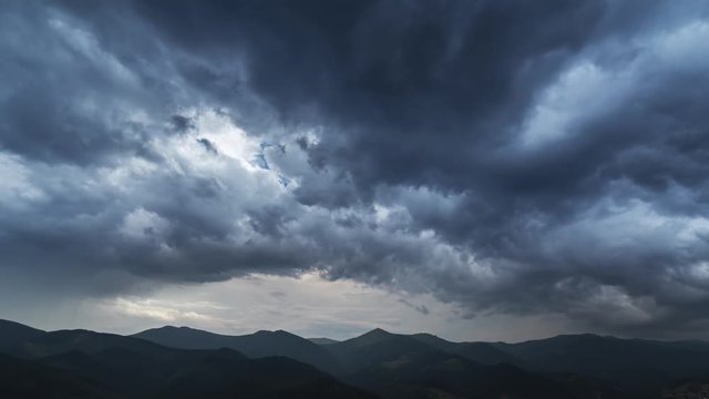 Timelapse of dark storm clouds passing by mountain range