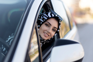 young muslim woman driving car