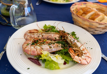 fried big shrimps with lettuce on white plate