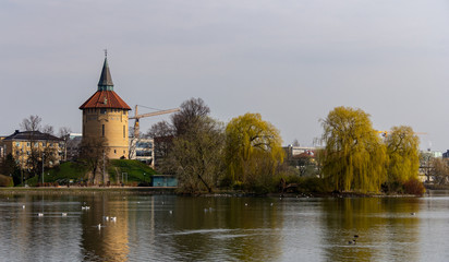 The old water tower and the lake in front of it in the park Pildammsparken in Malmö, Sweden, on a cold spring day