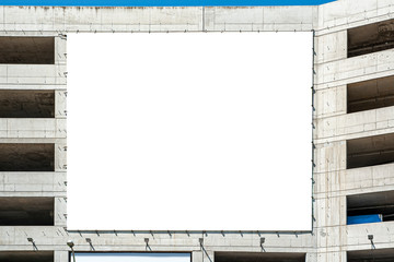 Huge blank white banner/billboard for advertisement on the facade of building under construction. Facade is finished with concrete.