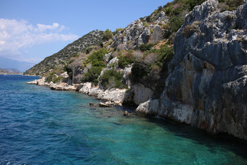 Fototapeta na wymiar The rocky slopes of the coast of Kekova island on which are the ruins of an ancient sunken city.