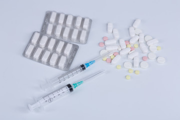 White pill, syringe and heroin on spoon. Drug addiction.