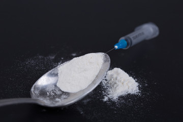 White pill, syringe and heroin on spoon. Drug addiction.